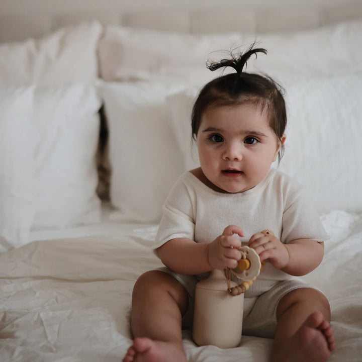 Toddler with FRIGG Snowflake Dream silicone pacifier - lifestyle photo showing pacifier in everyday use