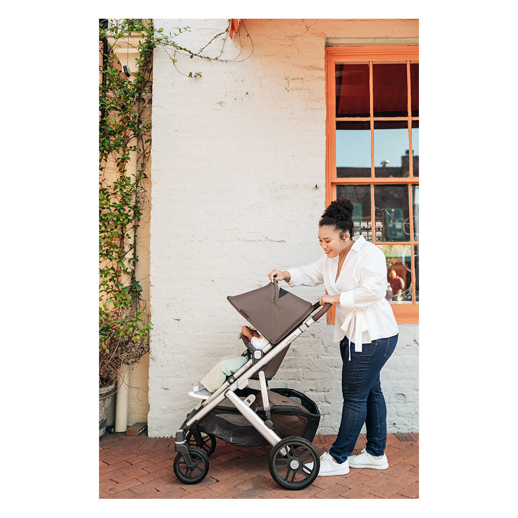 Woman looking at infant through mesh on vista in color theo by Uppababy