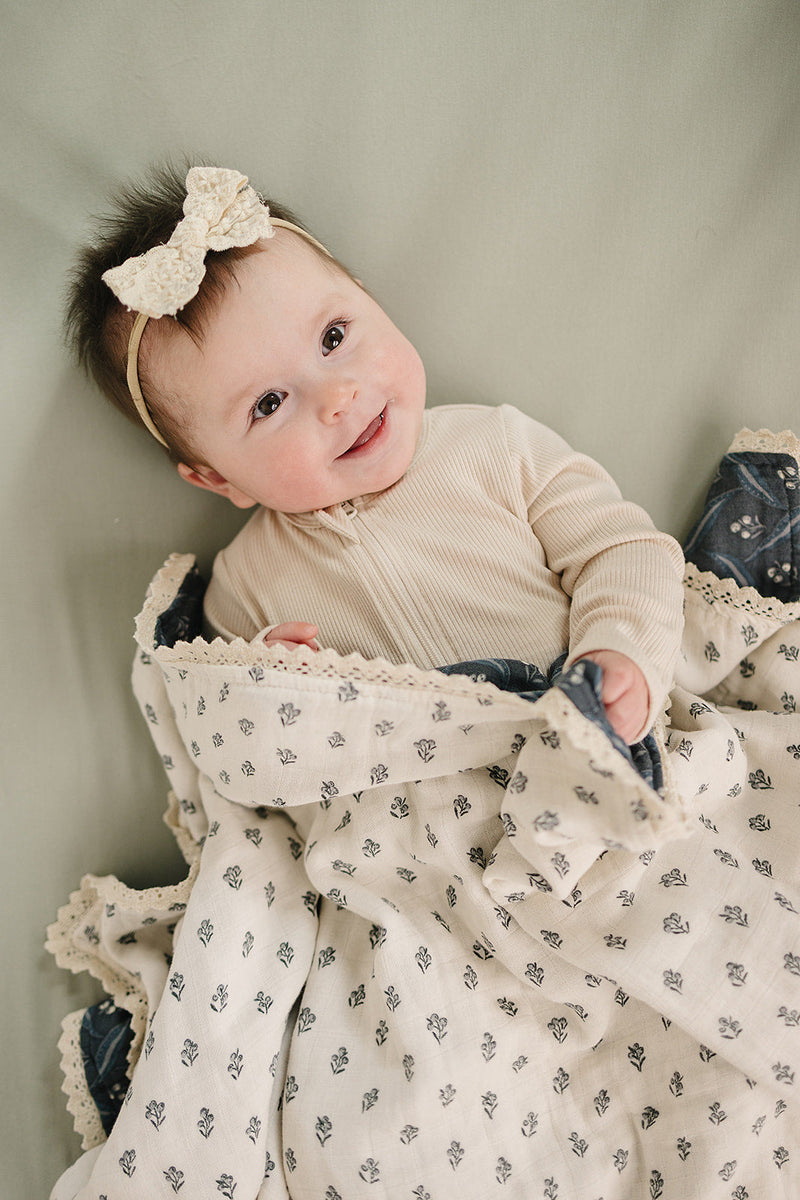 Gentle on sensitive skin, the Mebie Baby Navy Berry + Cream Berry Lace Muslin Quilt works as infant muslin blankets.