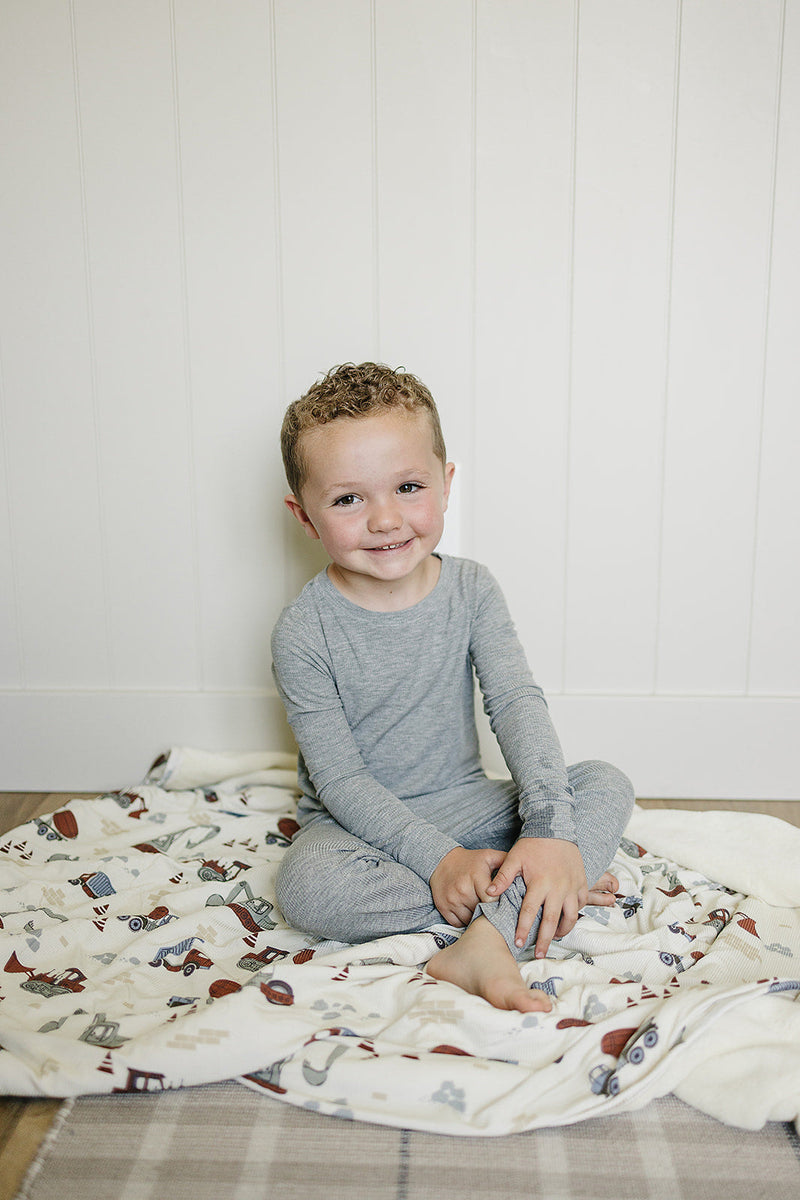 Wrap your child in the Mebie Baby Construction Trucks Ribbed Bamboo Fleece Quilt, perfect as a kids blanket.
