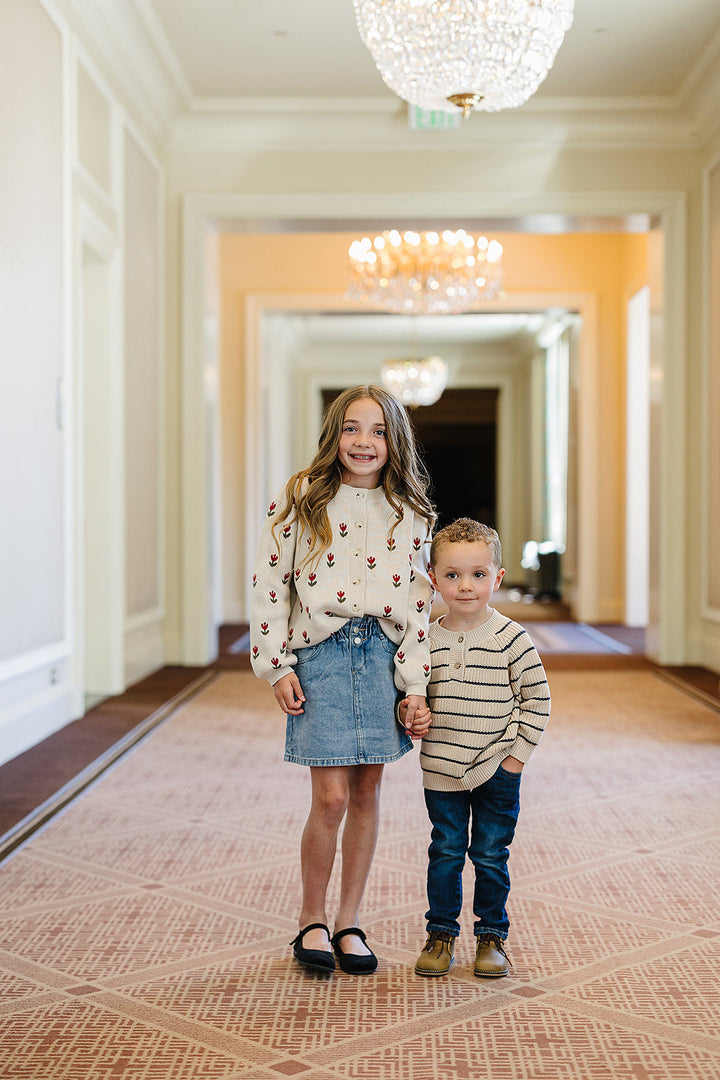 The Mebie Baby Tulip Button Down Cardigan combines comfort and charm, ideal for organic baby clothes wardrobes