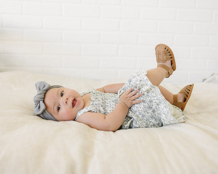Candid lifestyle shot featuring the Mebie Baby Palm Tree Linen Dress on a baby