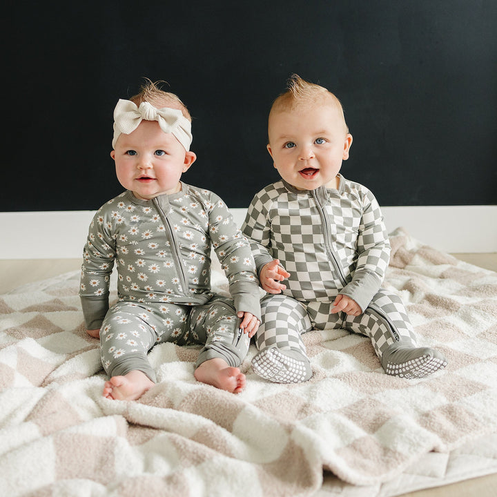 Styled flat lay of the Light Green Daisy Bamboo Zipper, a popular baby essential from Mebie Baby