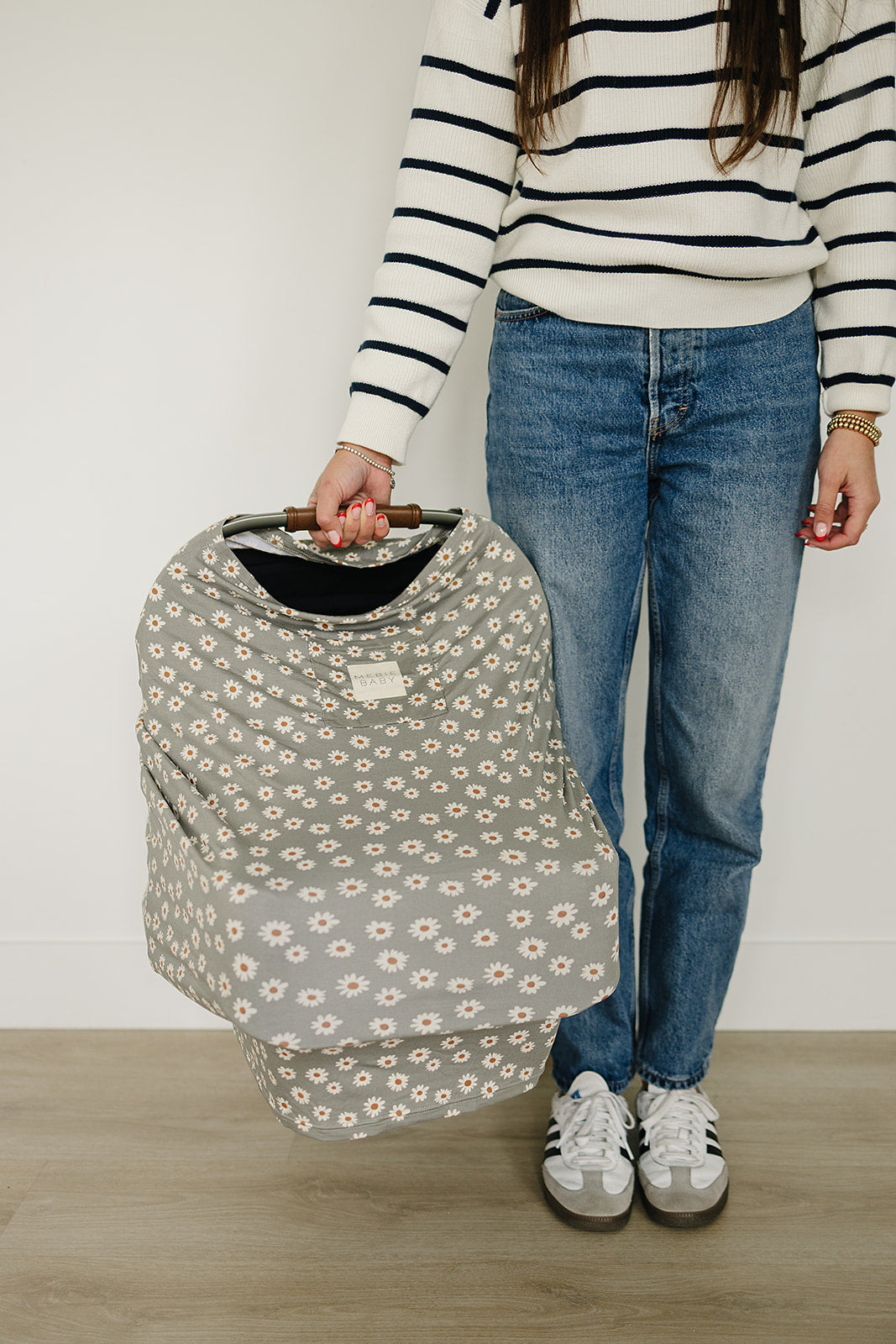 With a delicate daisy print, the Light Green Daisy Bamboo Multi-Use Cover by Mebie Baby serves as a flexible baby swaddle wrap.