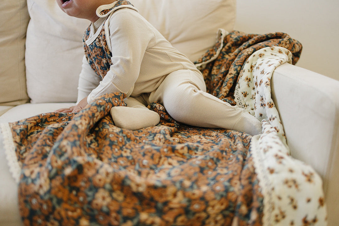 Wrap your child in the Mebie Baby Venetian Floral + Autumn Bloom Lace Muslin Quilt, a cozy muslin baby blanket.