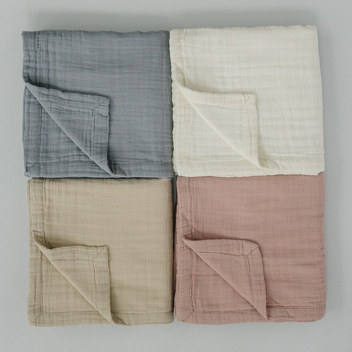 Folded neatly, the Dusty Blue Muslin Quilt from Mebie Baby is a gentle cotton muslin blanket for infants.