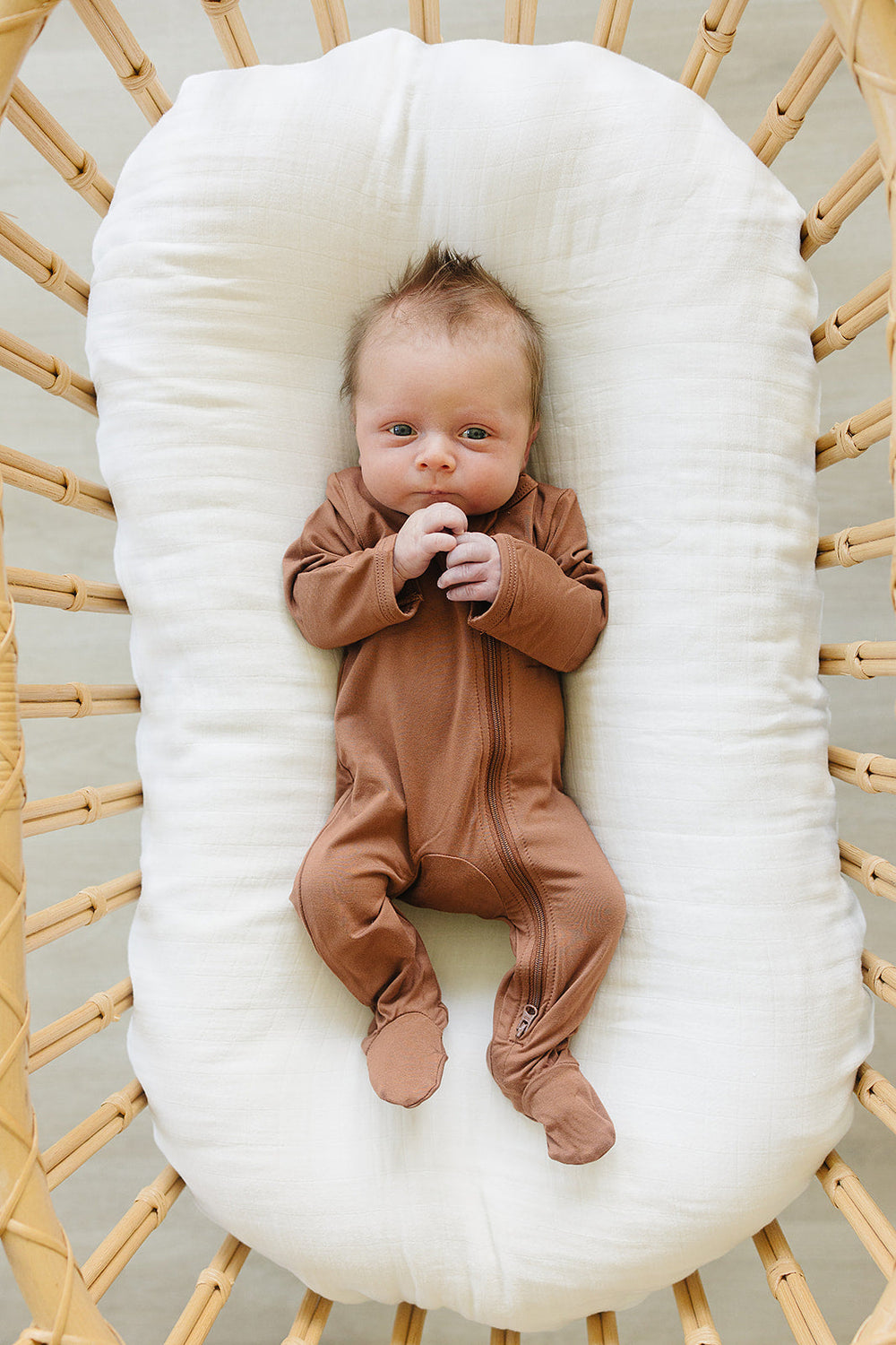 Mebie Baby Rust Bamboo Footed Zipper pictured alongside coordinating baby accessories