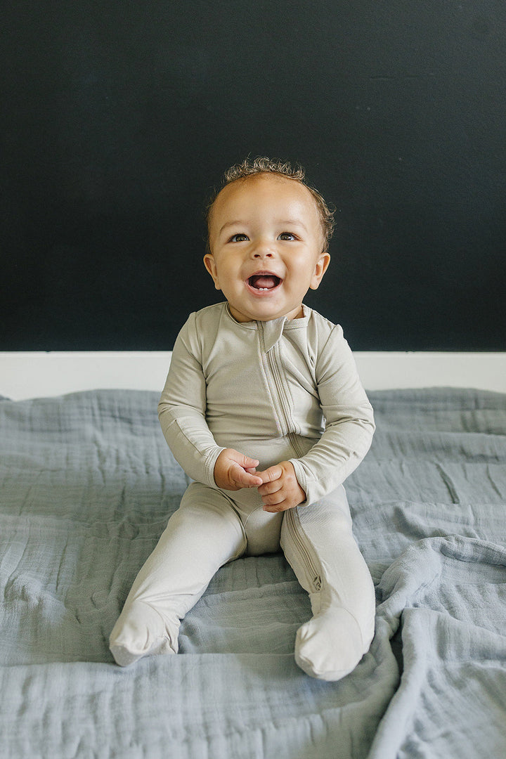 Draped over a nursery chair, this Mebie Baby Dusty Blue Muslin Quilt serves as a delicate muslin throw blanket.