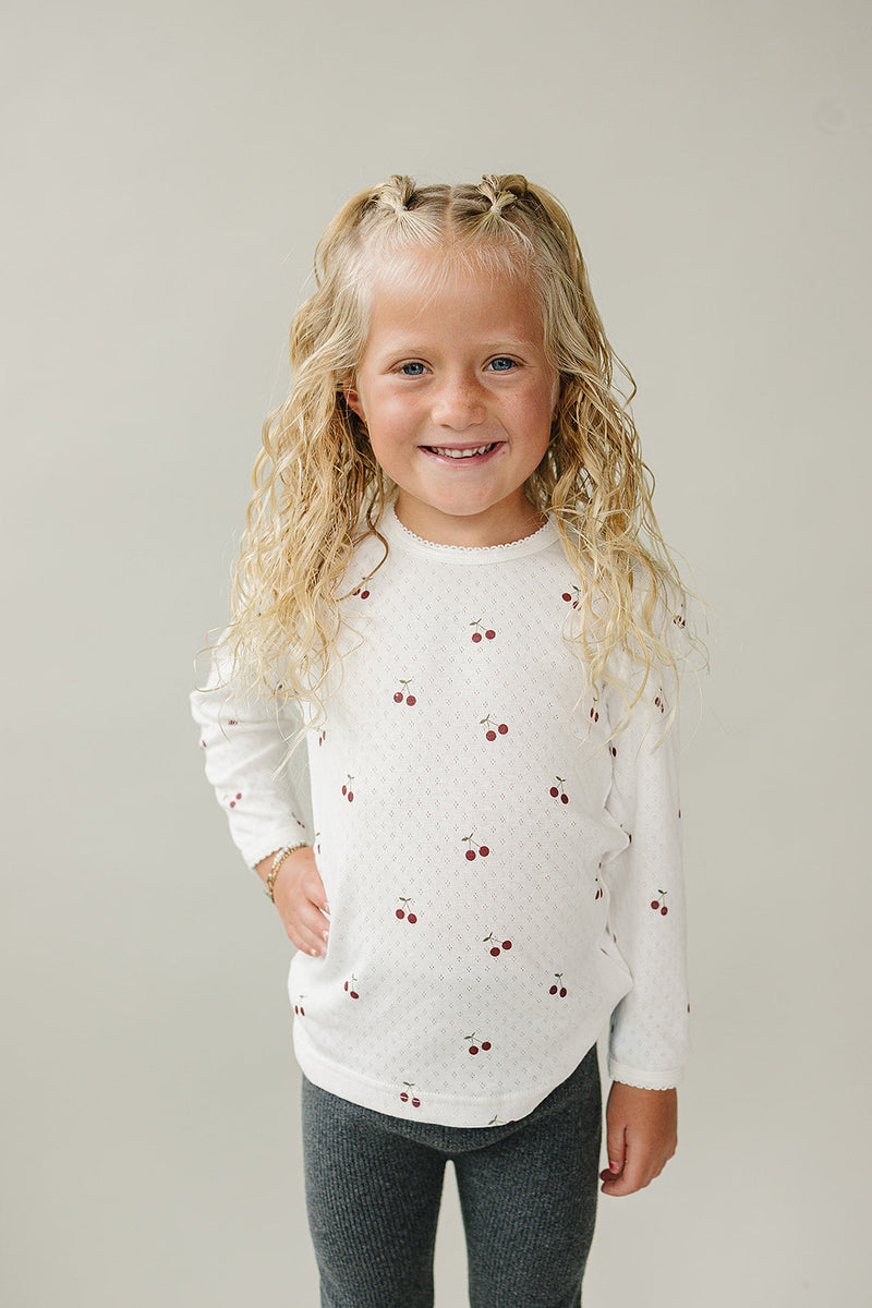 The Mebie Baby Cherry Pointelle Long Sleeve Tee features delicate knit texture, perfect for newborn baby clothes