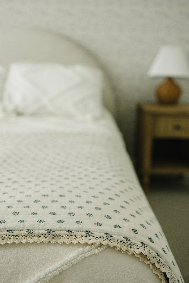 Nursery essential, Mebie BabyÕs Navy Berry + Cream Berry Lace Twin Muslin Quilt works as a soft muslin quilt.