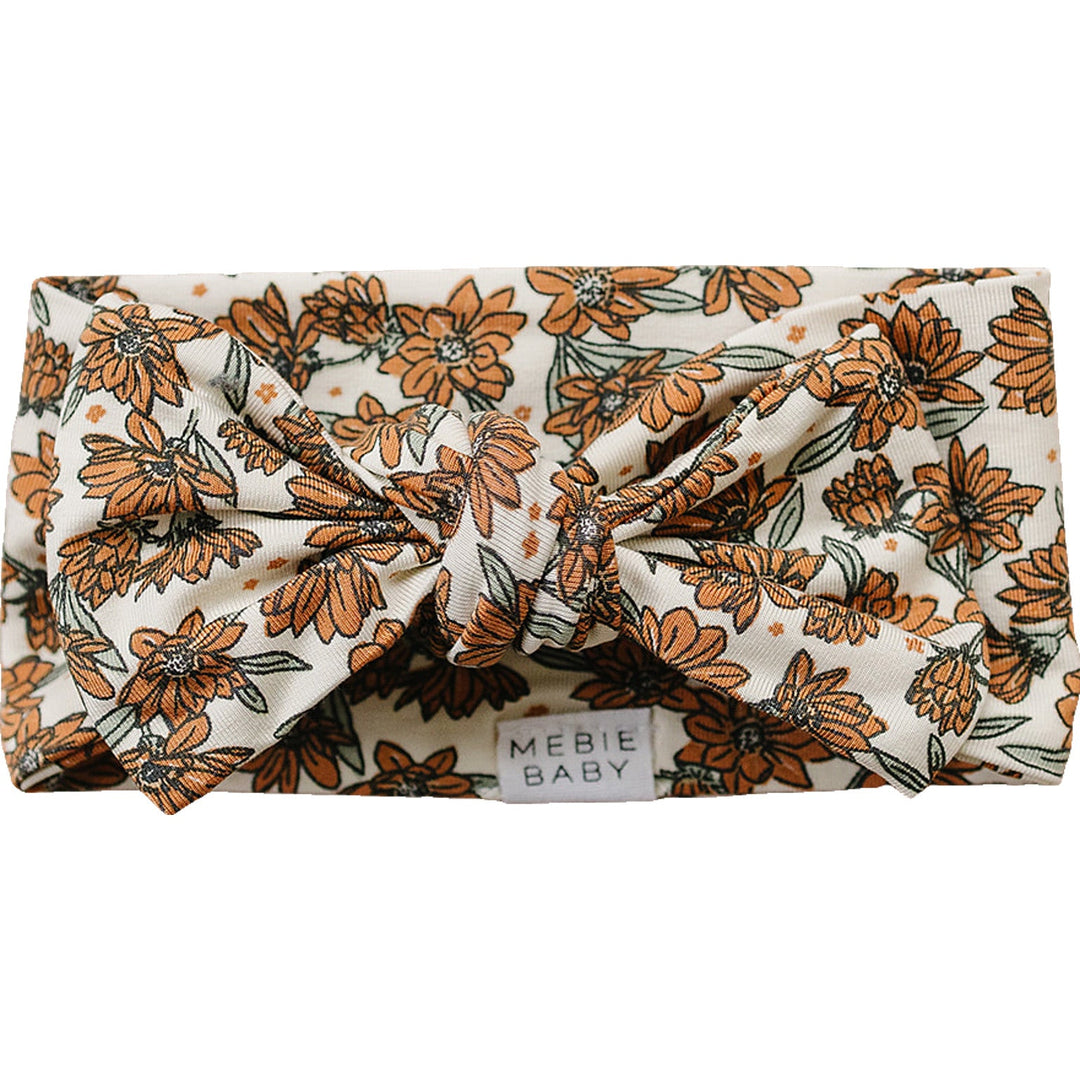 Mebie Baby Cream Magnolia Bamboo Head Wrap laid flat to show the fabric and design of this soft baby headband
