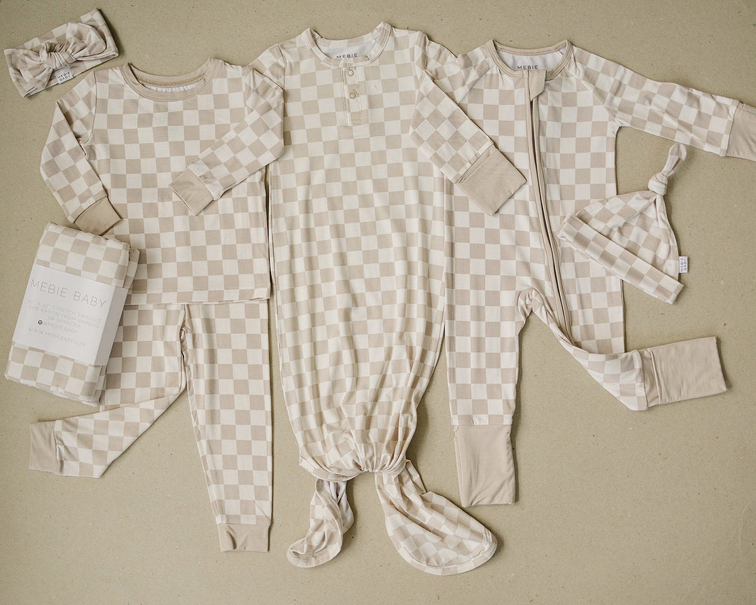 Baby modeling the Mebie Baby Taupe Checkered Bamboo Zipper, a soft nursery favorite for everyday wear