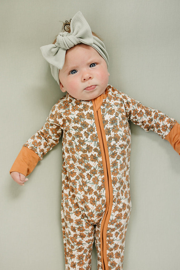 Baby wearing the Mebie Baby zipper magnolia footie pajamas