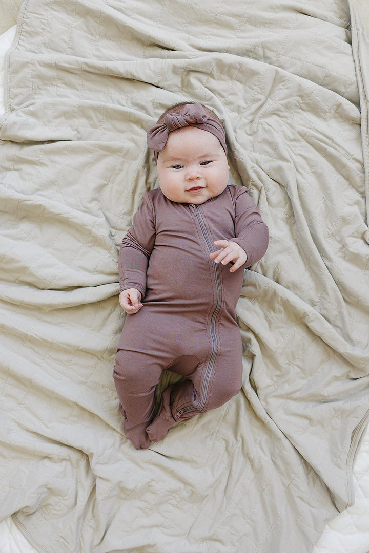 Soft texture close up of the Plum Bamboo Footed Zipper, a gentle footed baby pajama for babies