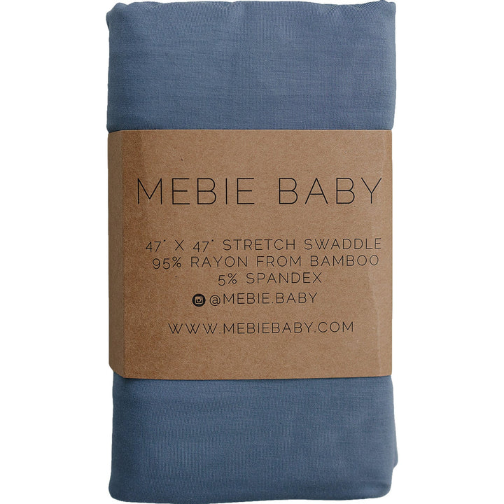 Dusty Blue Bamboo Stretch Swaddle by Mebie Baby, folded on a nursery shelf.