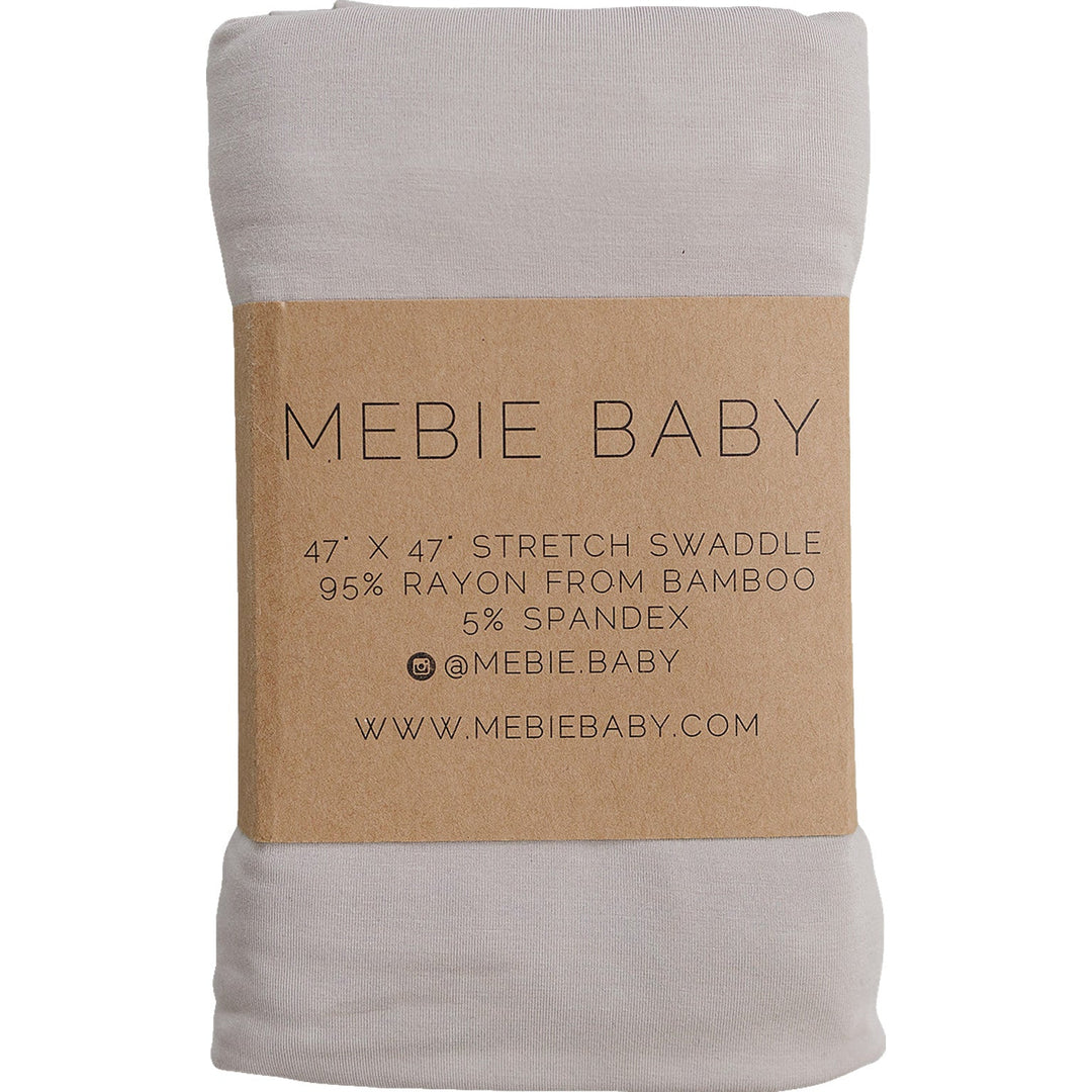 Oatmeal Bamboo Stretch Swaddle by Mebie Baby, folded on a nursery shelf.