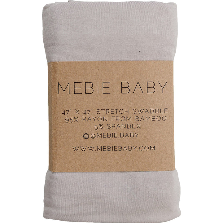 Oatmeal Bamboo Stretch Swaddle by Mebie Baby, folded on a nursery shelf.