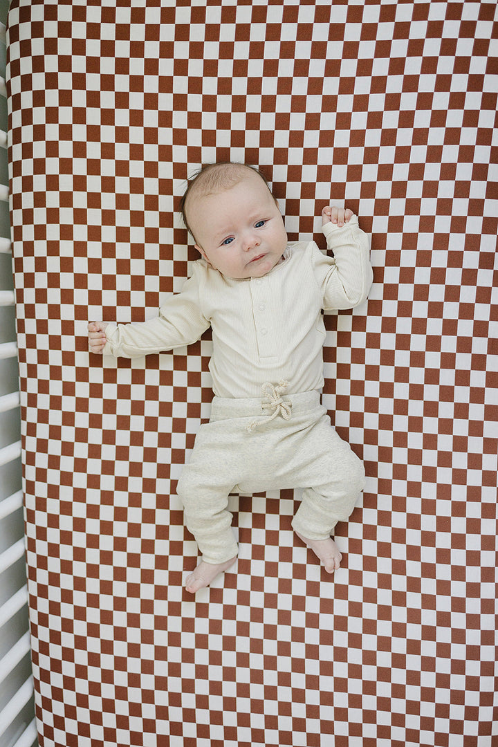 Baby modeling the Mebie Baby Cream Bamboo Snap Long Sleeve Ribbed Bodysuit, a soft ribbed baby bodysuit for everyday wear