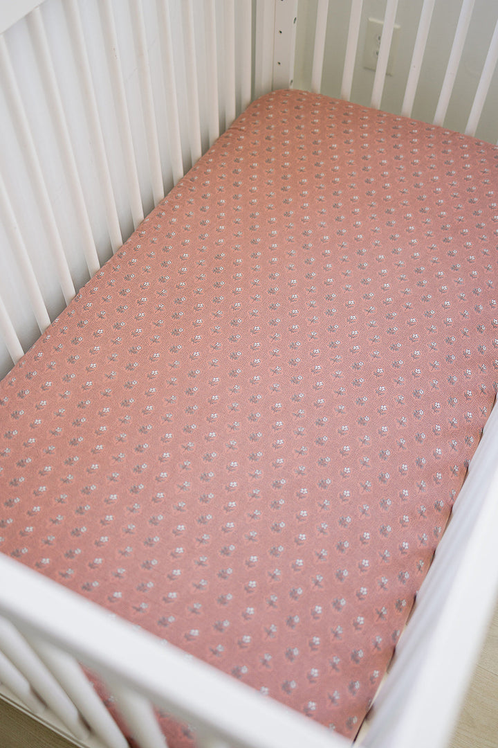 The Mebie Baby Vintage Pink Floral Muslin Crib Sheet provides a snug fit, ideal fitted crib sheets for infants.