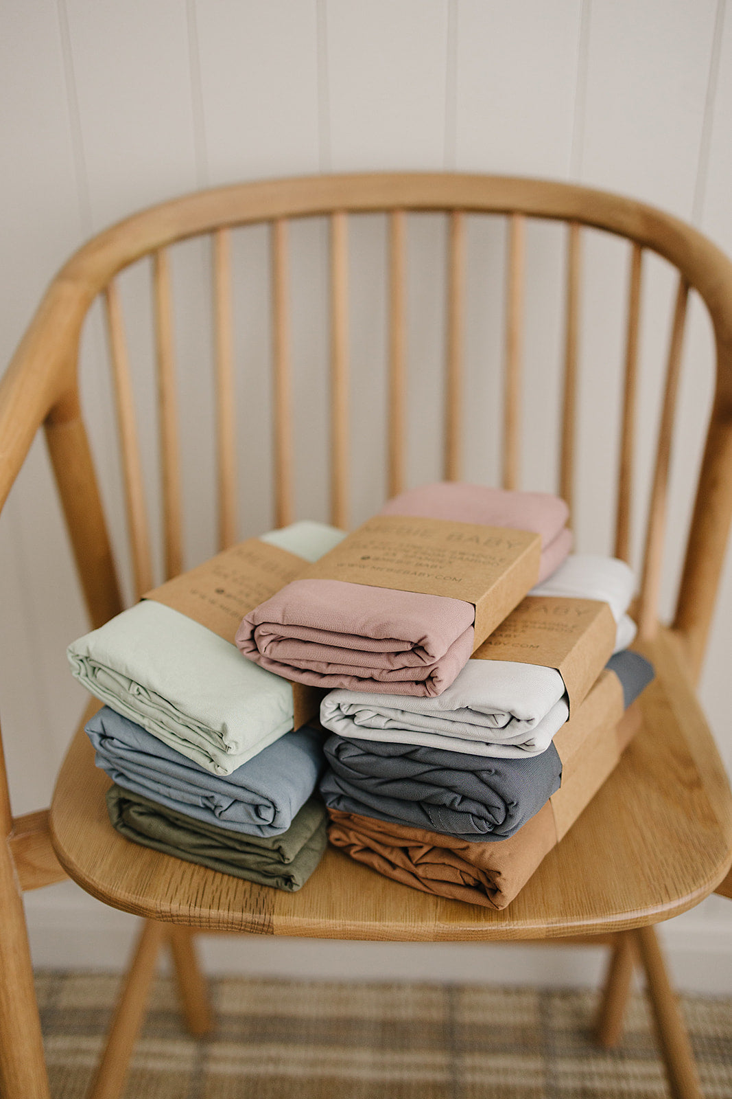Sage Bamboo Stretch Swaddle wrapped around a sleeping newborn, a breathable bamboo swaddle blanket for newborns.