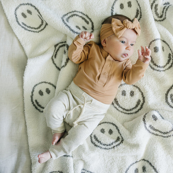Lifestyle photo of the Latte Bamboo Snap Long Sleeve Ribbed Bodysuit styled as a long sleeve baby bodysuit for little ones