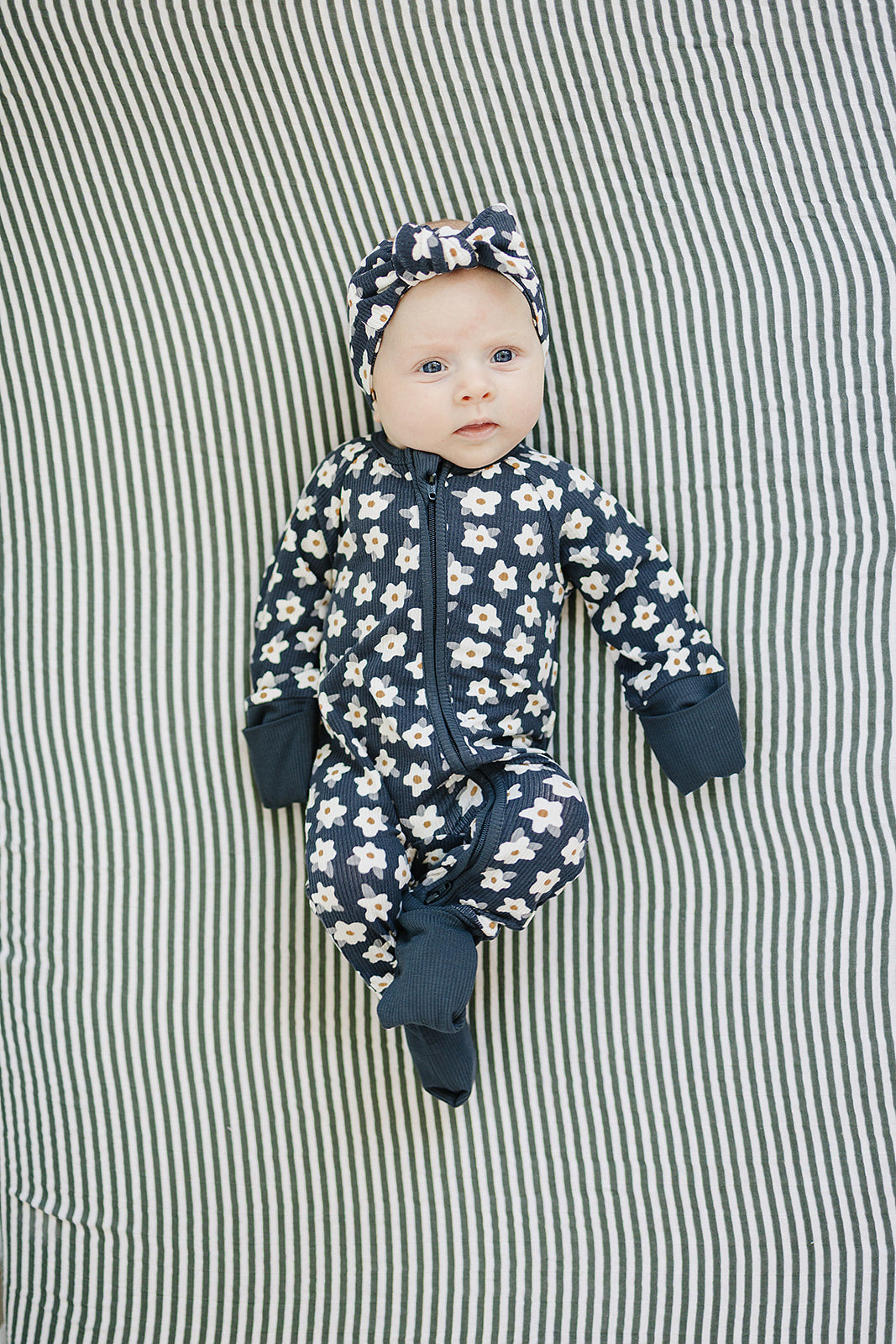 Designed with a smooth zip closure, the Mebie Baby Navy Daisy Ribbed Bamboo Zipper works perfectly as cozy onesie pajamas