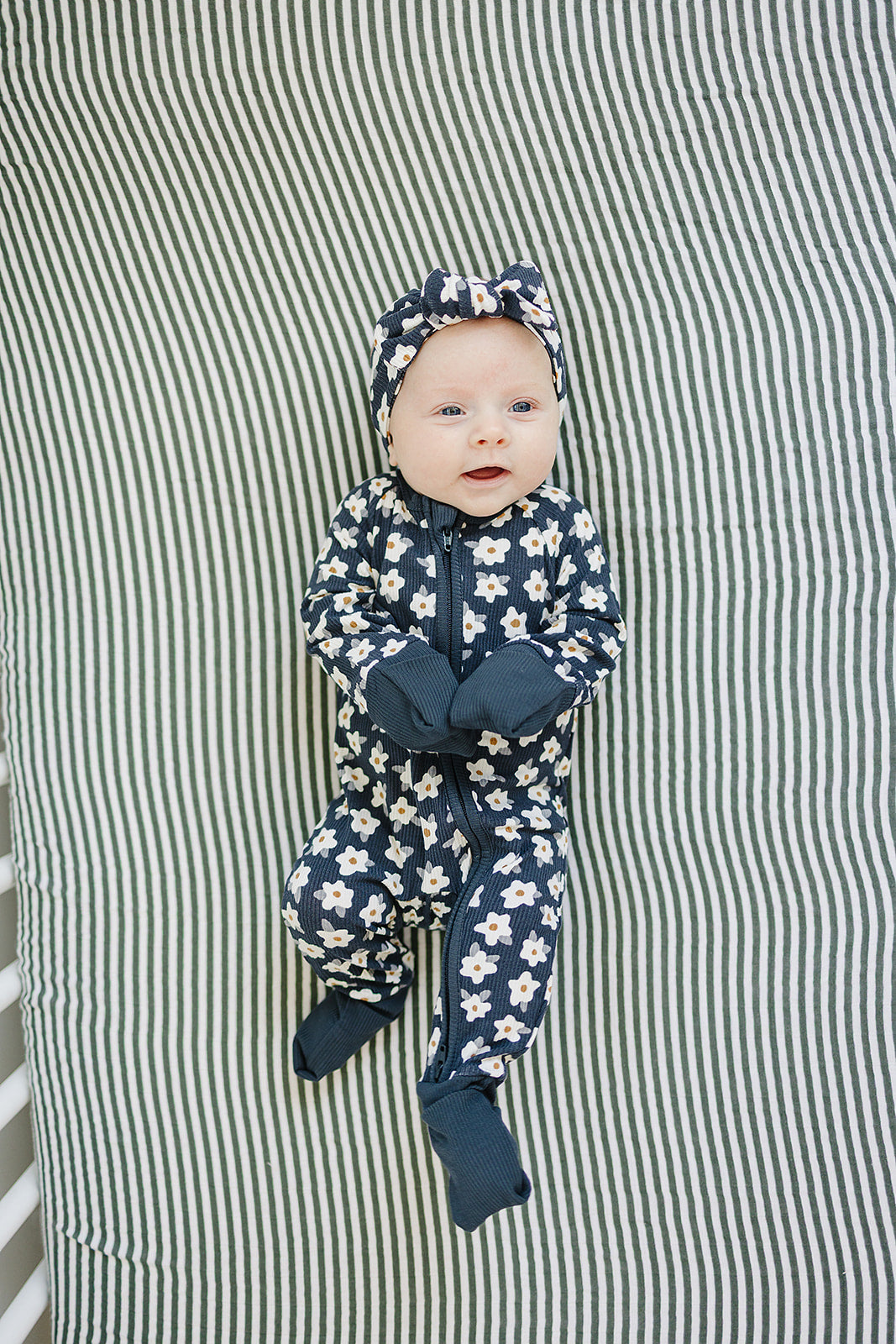 A playful daisy print defines the Mebie Baby Navy Daisy Ribbed Bamboo Zipper, ideal for sweet newborn onesies