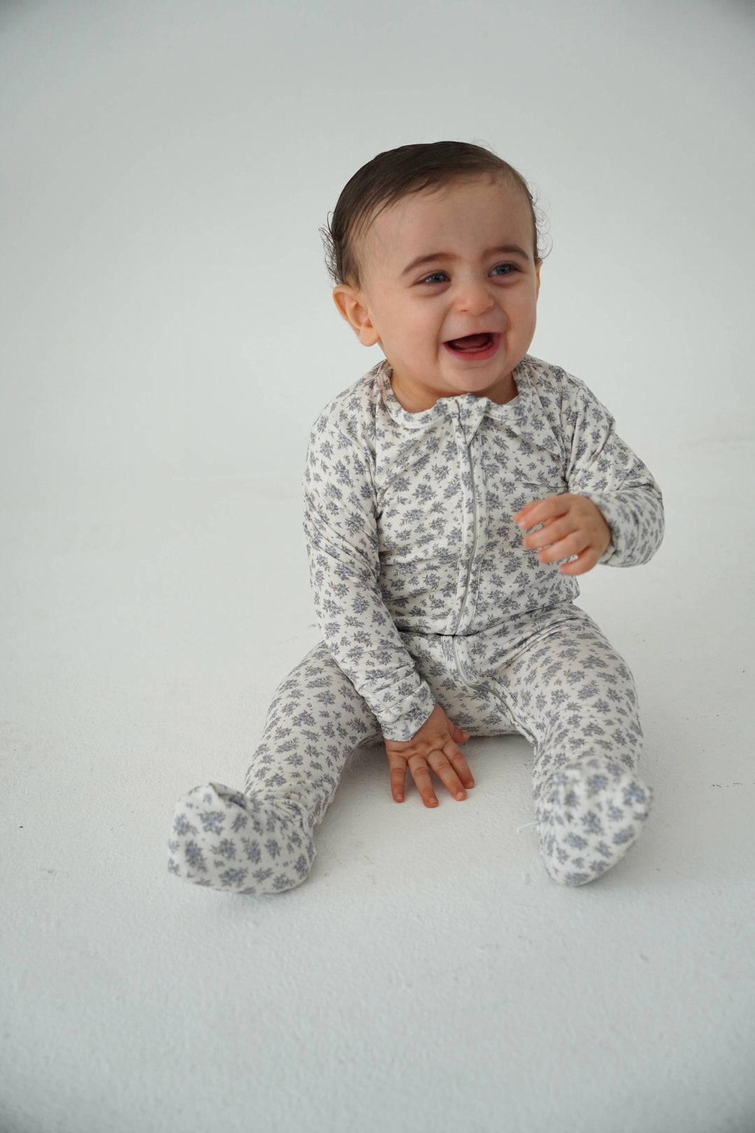 Baby wearing Little Threads vintage blue floral bamboo footie, soft infant sleepwear with zipper design for easy changes and all day comfort