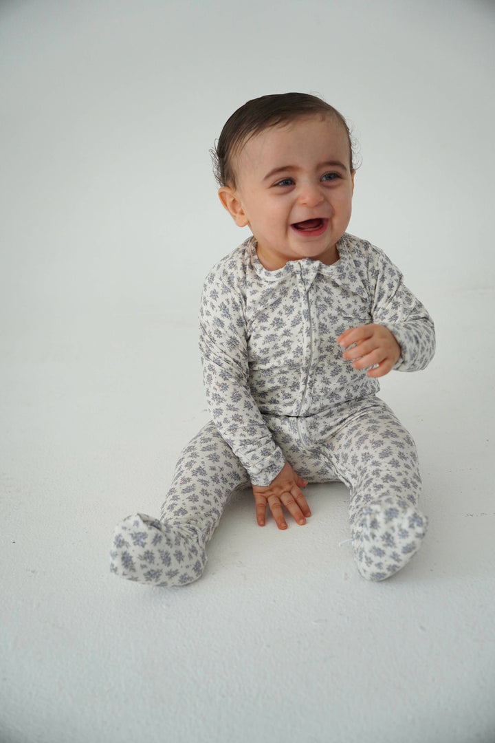 Baby wearing Little Threads vintage blue floral bamboo footie, soft infant sleepwear with zipper design for easy changes and all day comfort