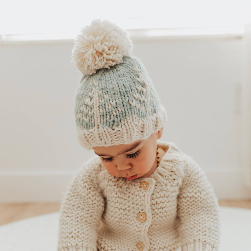 ice blue knit beanie with pom pom and tree details by hugg a lug on toddler 