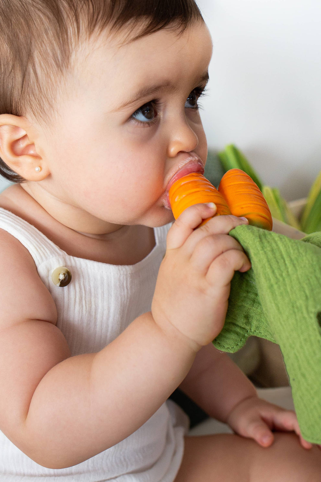 Baby using Oil & Carol Cathy the Carrot teether, infant teething toy and comfort doudou for chewing, grasping, and sensory play