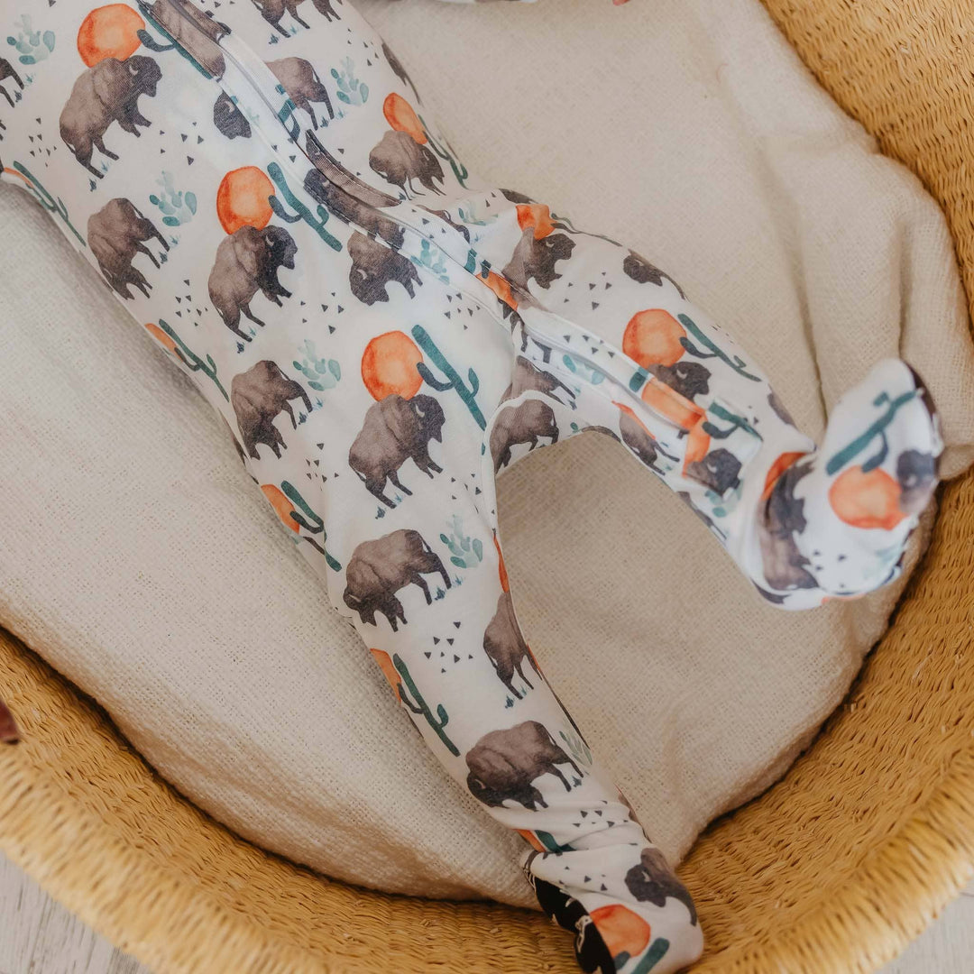 Baby lying in Copper Pearl Bison footie pajamas, cozy infant sleepwear for naps and nighttime routines