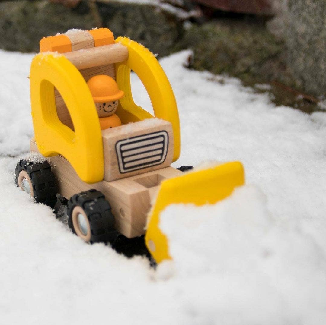 Wooden front loader for pretend play from Goki shoveling snow outside