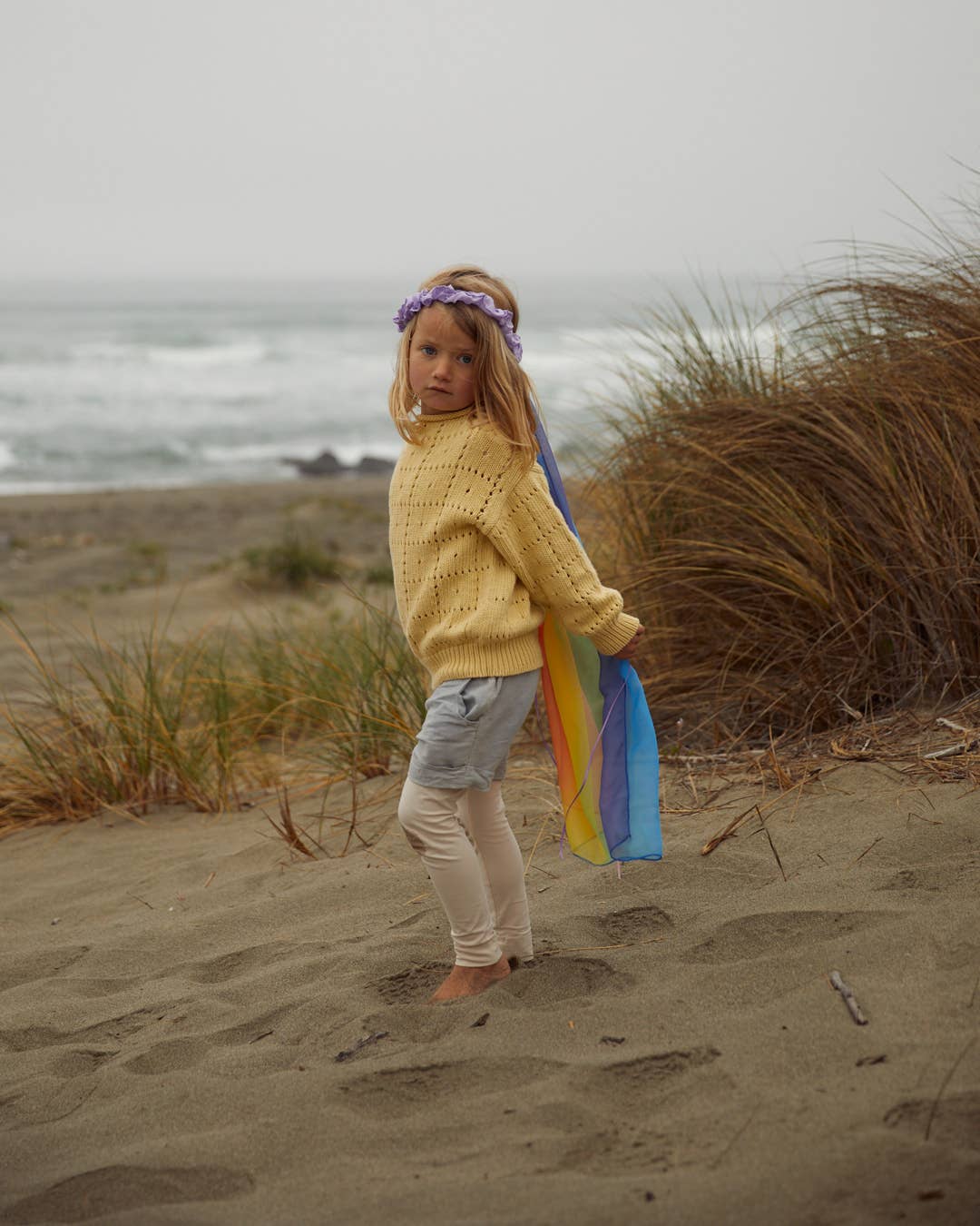 Sarah's Silks best selling children's toy, child in profile wearing the Rainbow Veil at the beach