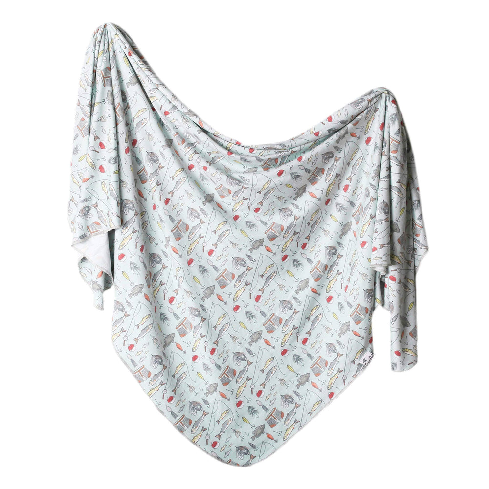 Newborn swaddled in Copper Pearl Trout knit receiving blanket