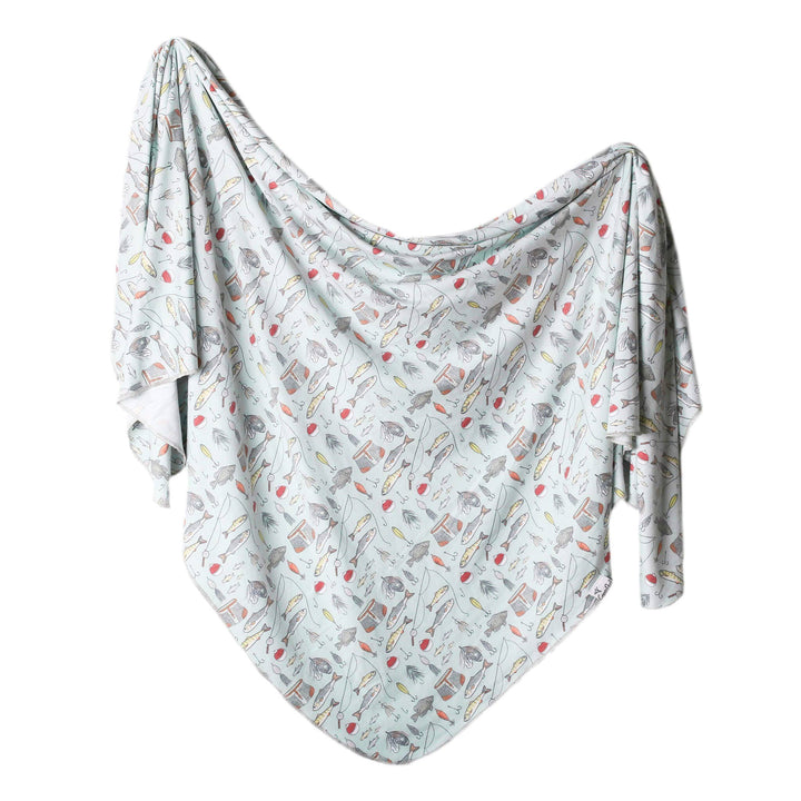 Newborn swaddled in Copper Pearl Trout knit receiving blanket