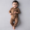 Baby wearing the adorable zipper romper in the shade coffee.