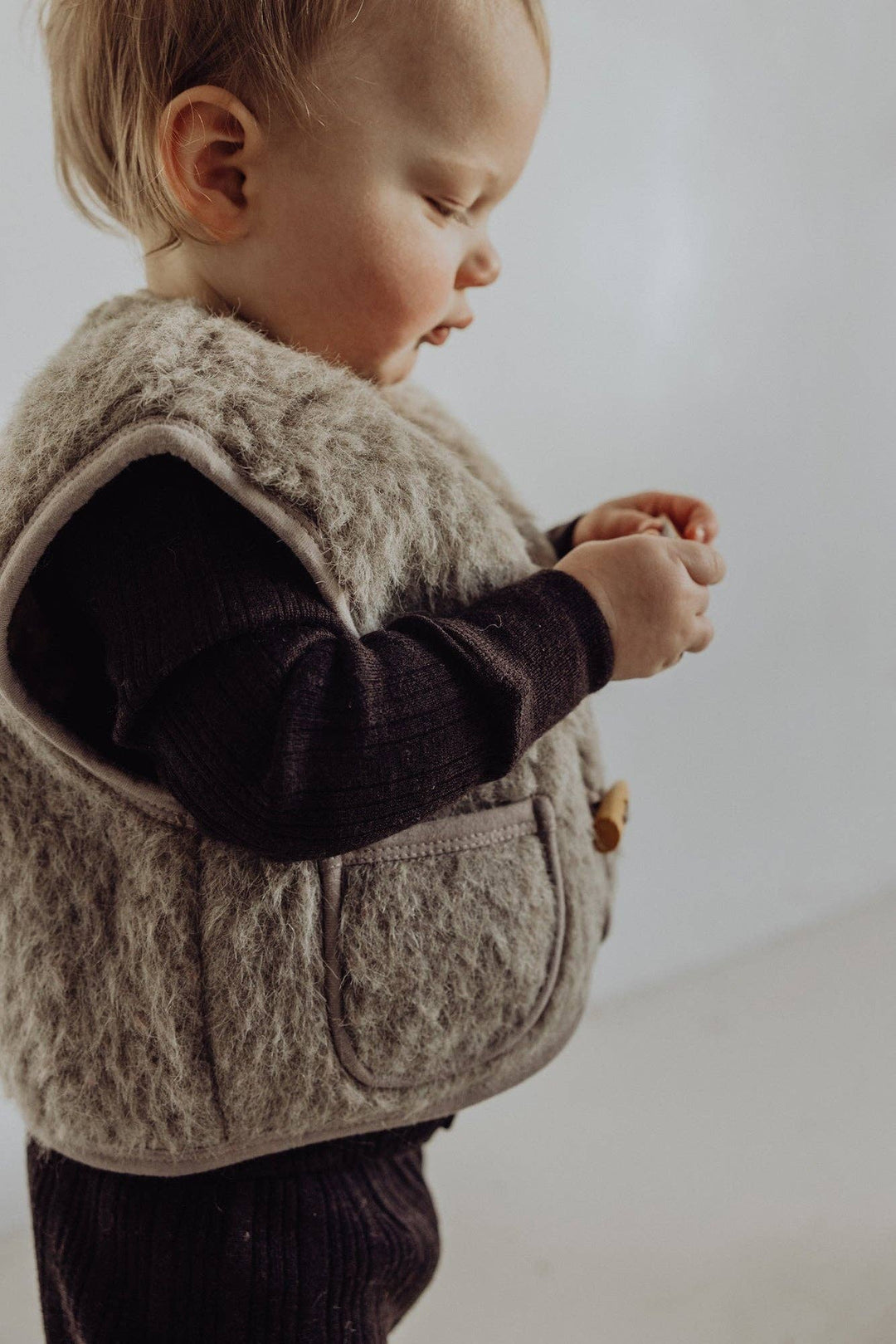 On an infant, the Finch & Fable Wool Sherpa Vest Ð Sand delivers warmth and style found in premium newborn baby clothes