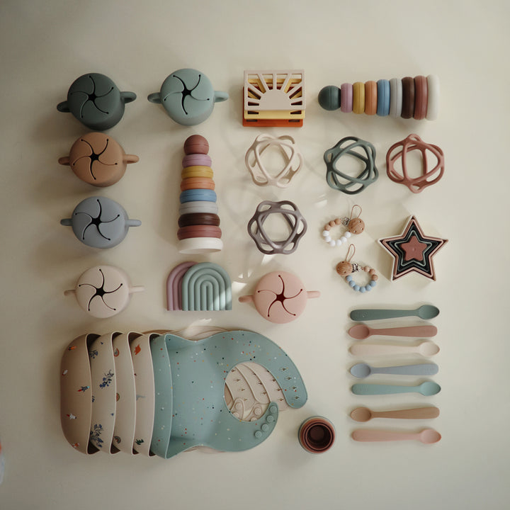 Assorted silicone Mushie products crafted for safety and comfort during teething