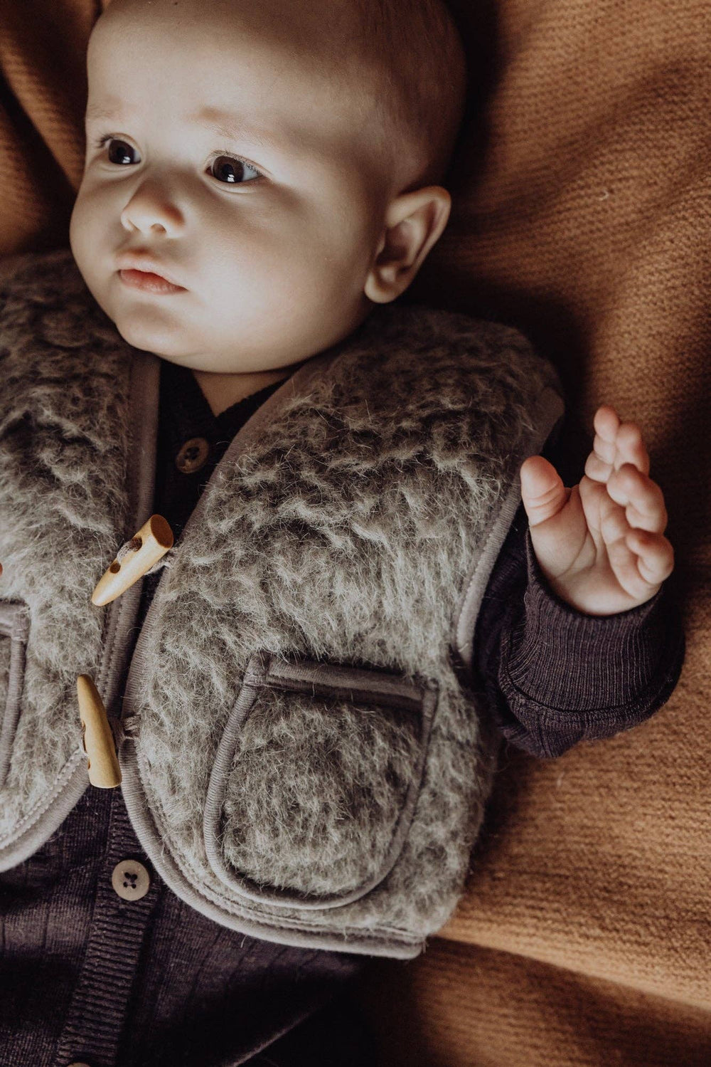 A detailed texture shot shows the Finch & Fable Wool Sherpa Vest Ð Sand, designed with comfort in mind for baby clothing