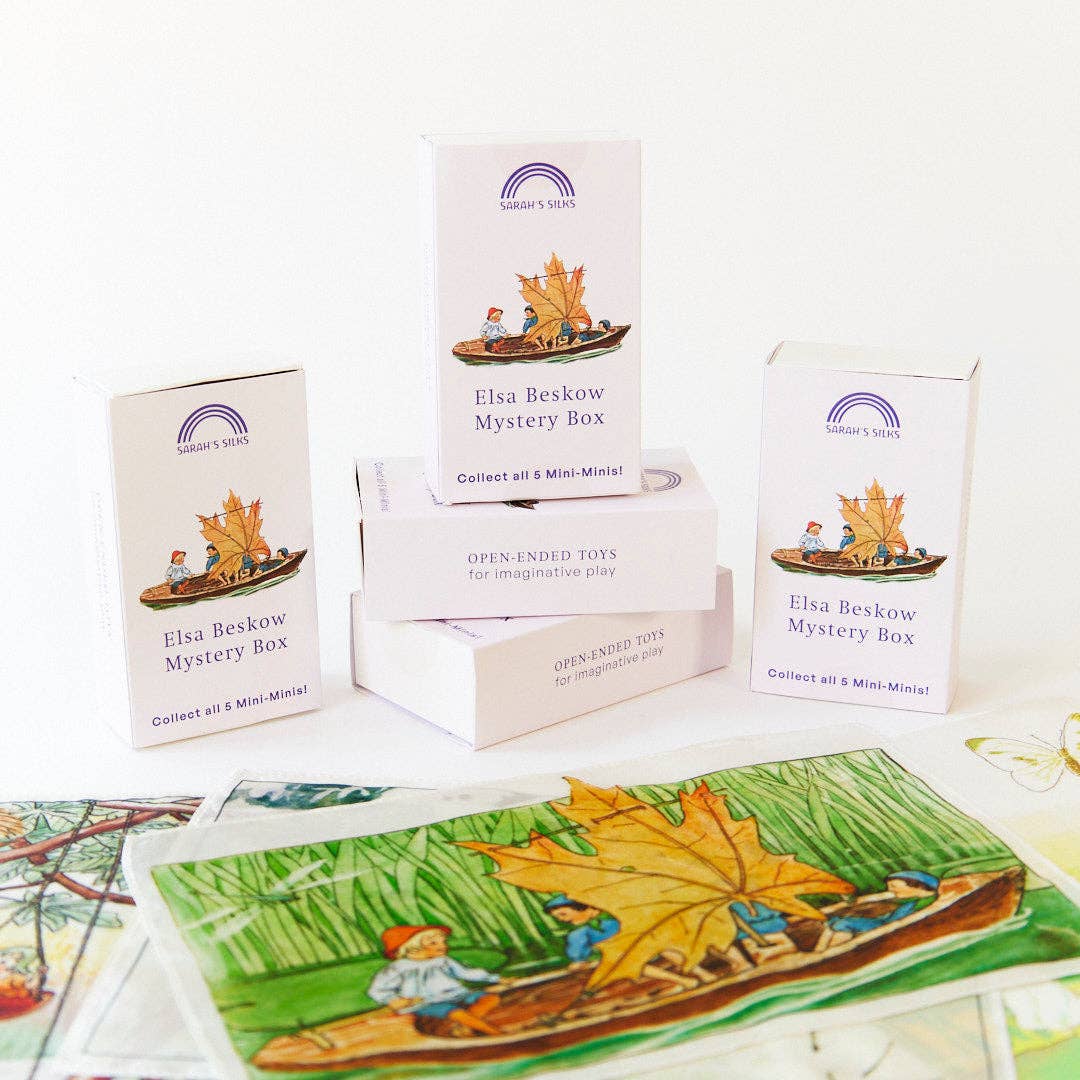 Stacked mystery boxes rest atop a hand painted scene, part of the Elsa Beskow Mini Mystery Playsilk line