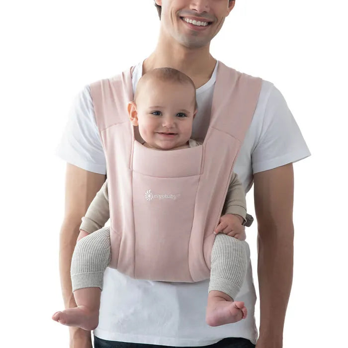 Keep baby close in the Ergobaby Embrace Newborn Carrier, shown here in Blush Pink, your go-to baby carrier.