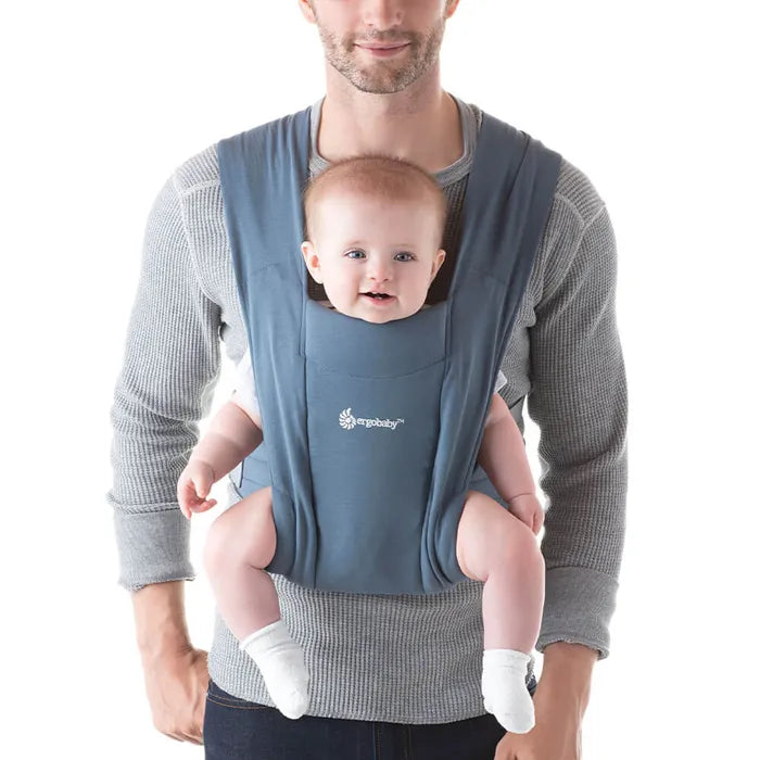 Enjoy structured comfort with the Ergobaby Embrace Newborn Carrier in Oxford Blue, an excellent baby carrier for travel.