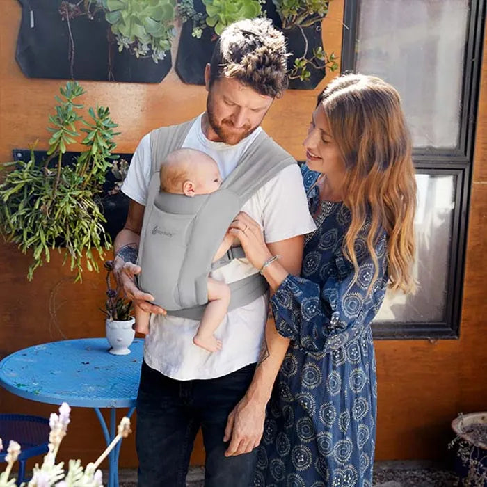 Designed for airflow, the Soft Grey Ergobaby Embrace Newborn Carrier keeps baby close as a front baby carrier.