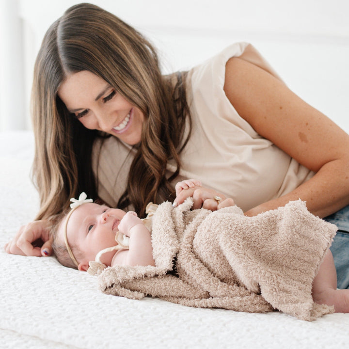 Cuddle time feels extra special with the Saranoni BAMBONI¨ Mini Blanket in Taupe, the best baby blanket for warmth and comfort.