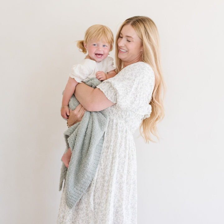 The Saranoni Bamboni¨ Receiving Blanket in Sage blends cozy warmth with modern design, perfect for baby receiving blankets.