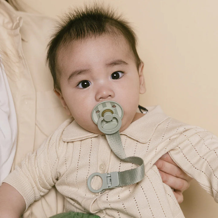 Model wearing BIBS Pacifier Clip Sage, secure option for newborn pacifiers.