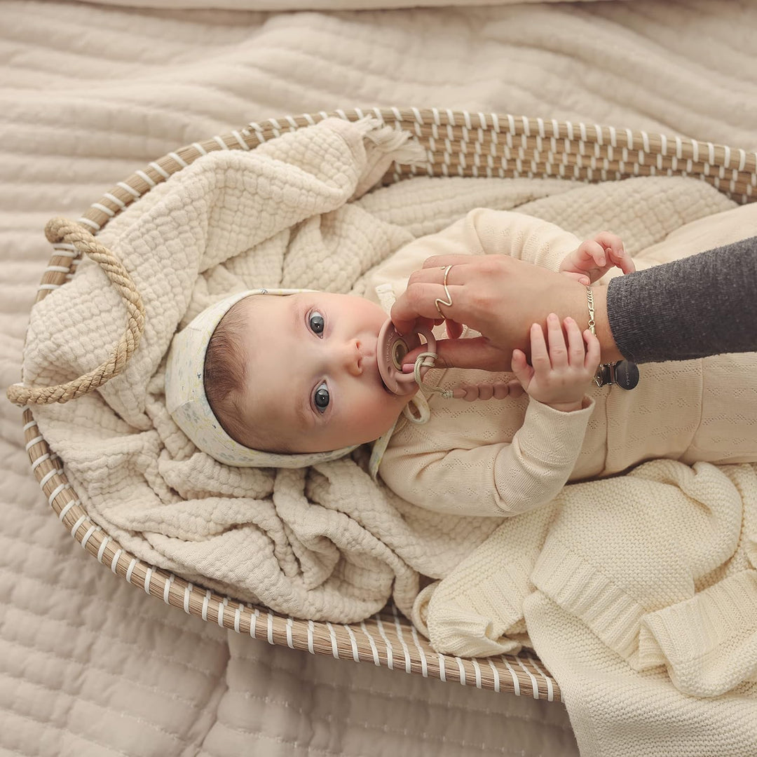 Baby lying in a basket with the Heritage Knit Organic Luxury Blanket and Swaddle