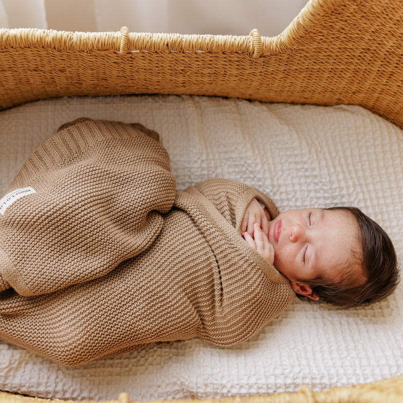 Newborn baby wrapped in a swaddle, the Bleu La La Heritage Heritage Knit Organic Cotton Swaddle Blanket in Mocha