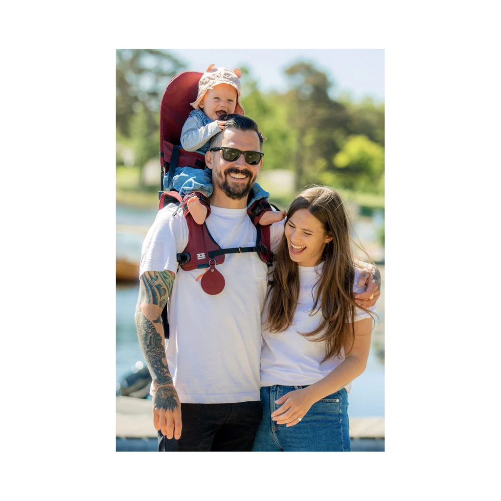 Happy family using the burgundy shoulder carrier